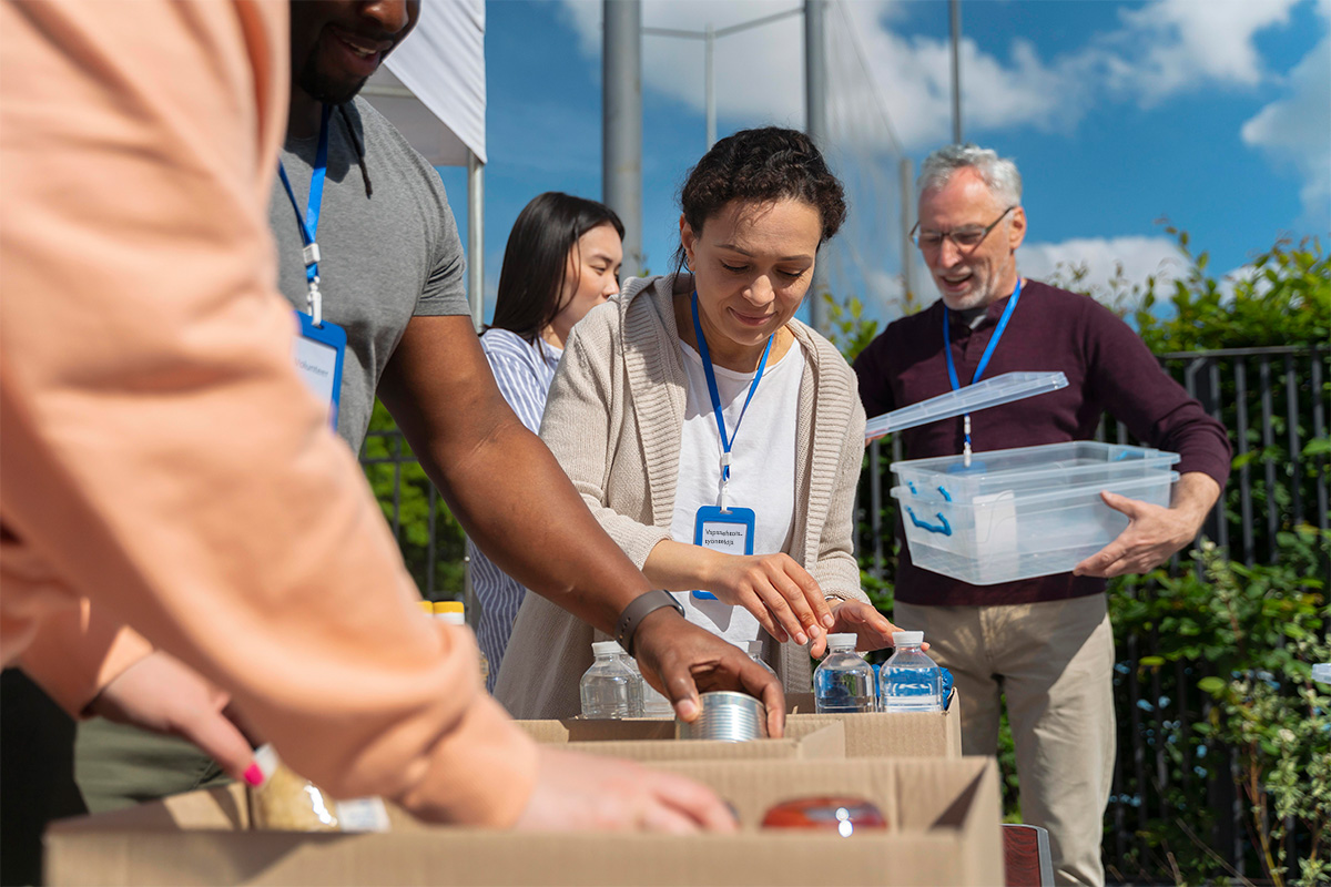 Vapaaehtoistyöntekijöitä pakkaamassa elintarvikkeita pahvilaatikoihin.