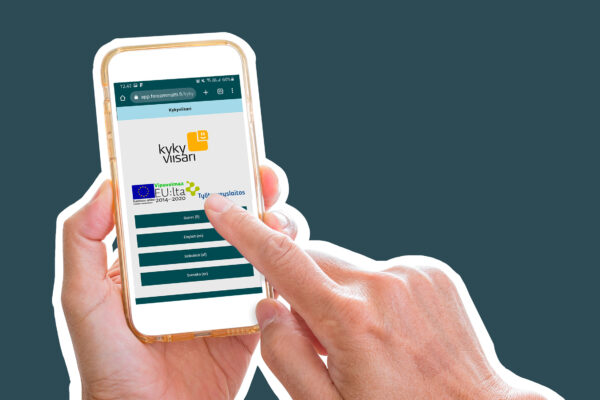 Vasen käsi pitelee älypuhelinta, jonka ruudulla näkyy ForeAmmatin Kykyviisari palvelun aloitusnäkymä. Oikean käden etusormi on painamassa ruudulta suomen kielivalintaa. Käsien ja puhelimen tausta on tasainen tummanvihreä.